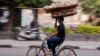 FILE - An Egyptian balances a basket of bread, in Cairo, Dec. 8, 2016.