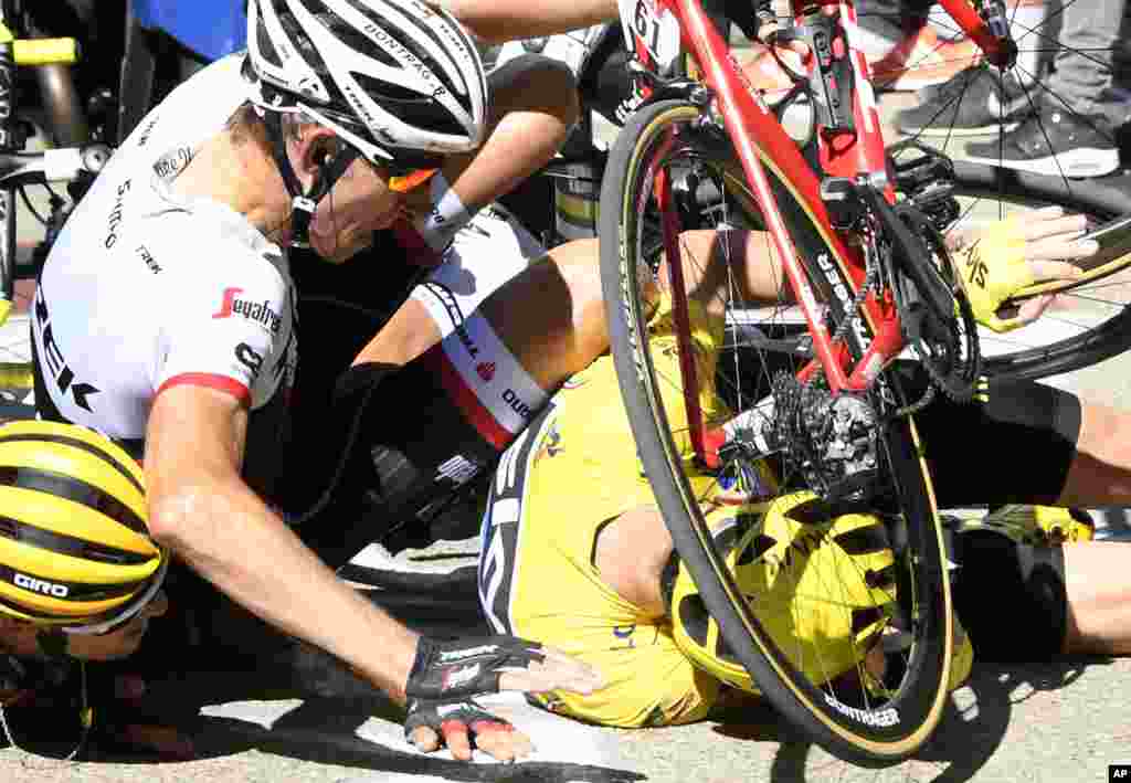 Britain's Chris Froome, wearing the overall leader's yellow jersey, right, Netherlands’ Bauke Mollema, center, and Australia’s Richie Porte crash at the end of the twelfth stage of the Tour de France cycling race with start in Montpellier and finish six kilometers (3.7 miles) before the Mont Ventoux, France.