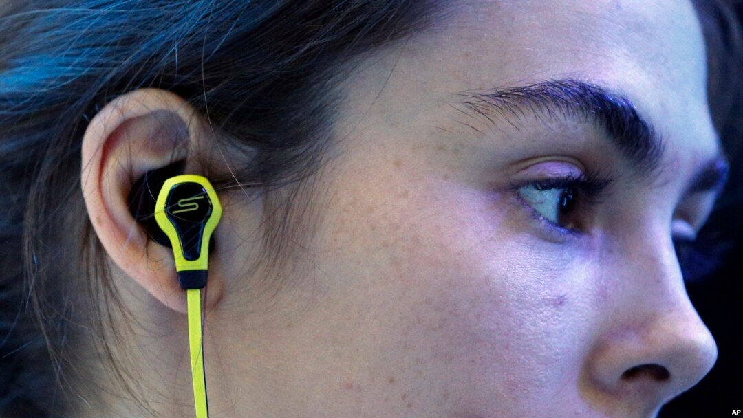 A model wears SMS Audio BioSport In-Ear Headphones at the Intel booth during the International CES, in Las Vegas, Jan. 6, 2015.