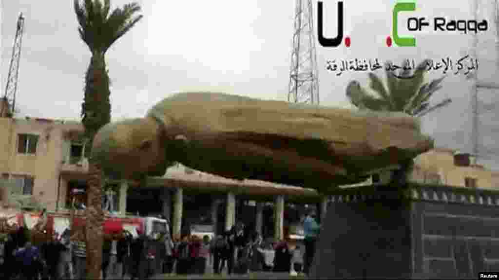 A statue of Syrian President Bashar Al-Assad's father, Hafez Al-Assad, is pulled down as people celebrate in Raqqa, March 4, 2013. 