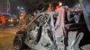 Soldiers stand near the wreckage of a suicide car bomb outside Somalia's presidential palace, Sept, 21, 2015.