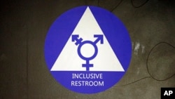 FILE - A sticker designates a gender-neutral bathroom at Nathan Hale high school in Seattle, May 17, 2016.