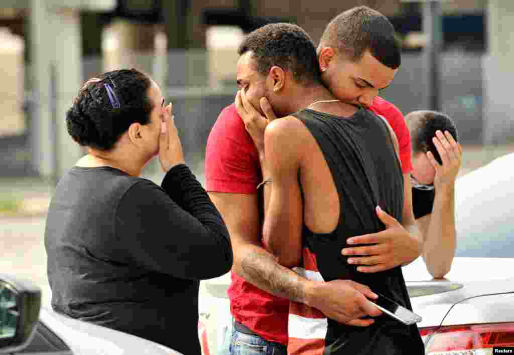 Friends and family members embrace outside the Orlando Police Headquarters during the investigation of a shooting at the Pulse night club, in Orlando, Florida, where as many as 50 people were killed and at least 53 people were injured after a gunman opened fire.