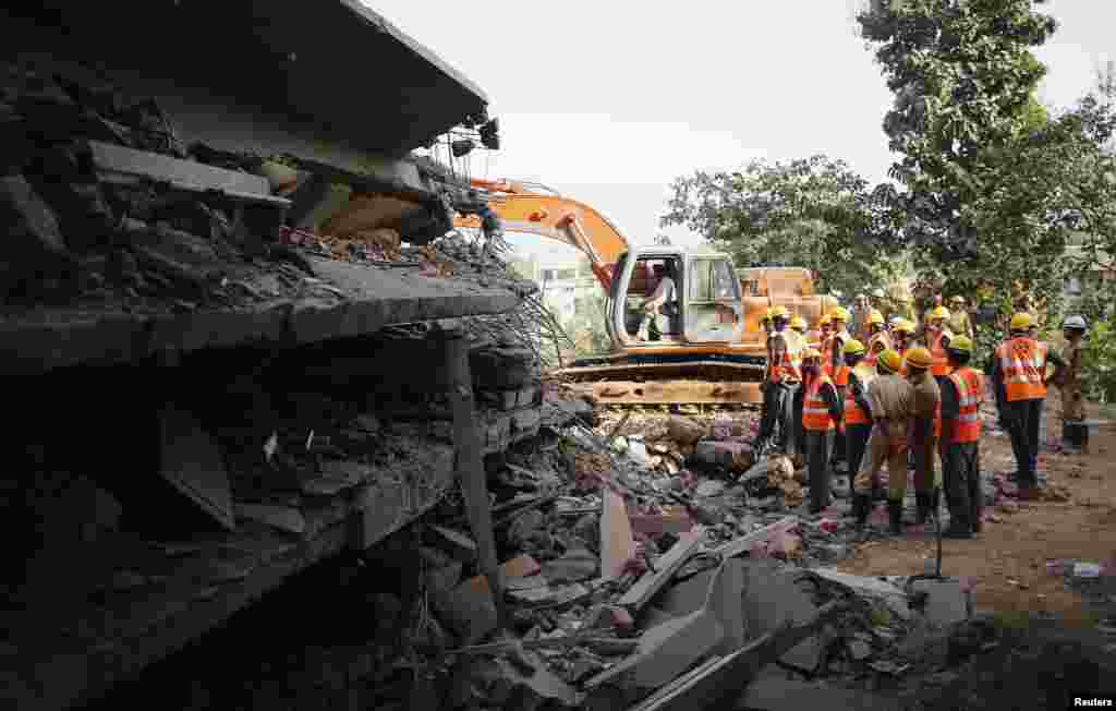 Rescuers search for survivors at the site of a collapsed building, Canacona, India, Jan. 5, 2014.