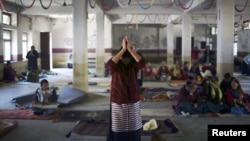 A Tibetan woman offers prayer upon her arrival to an event organized to express solidarity with the victims of violence in Tibet and to those who self-immolated to protest against Chinese rule in Tibet, in Kathmandu, November 17, 2012. 