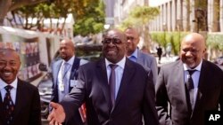 Photo d’archives : Le ministre des Finances sud-africain Nhlanhla Nene (limogé mercredi 9 décembre 2015), au centre, arrive au Parlement sud-africain à Cape Town pour prononcer le discours du budget annuel, mercredi 25 février 2015.