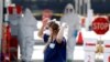 FILE - A Medical University of South Carolina worker adjusts her mask in Charleston, S.C., March 13, 2020.