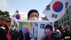 Pristalica opozvanog južnokorejskog predsednika Jun Suk Jola drži plakat sa Junom i novoizabranim predsednikom SAD Donaldom Trampom koji se prevodi kao "Reagovao je slanjem svojih posebnih pozdrava narodu Južne Koreje", u Seulu 6. januara 2025.