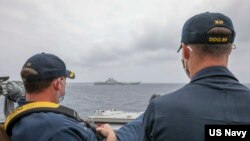美国海军照片显示两名军官2021年4月4日在驱逐舰“马斯廷号”上近距离观察中国"辽宁号"航空母舰（美国海军）