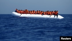 Des migrants attendant d'être secourus le 3 août 2015 par le bateau MV Phoenix à environ 32 km des côtes libyennes, 