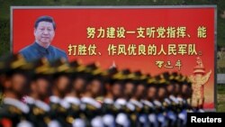资料照：解放军士兵列队在中国领导人习近平画像以及他提出的“能打胜仗，作风优良”的口号前走过。（2015年8月22日）