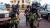 Fighters for the Seleka rebel alliance stand guard in front of the presidential palace in Bangui, March 25, 2013. 