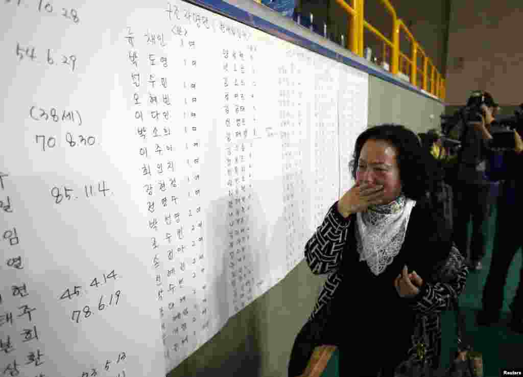 Ibu seorang penumpang dalam kapal yang tenggelam bereaksi saat menemukan nama putranya dalam daftar penyintas di sebuah klub kebugaran tempat para penumpang yang selamat berkumpul di Jindo, Korea Selatan (16/4).