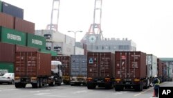 A port security guard stands near containers piled up at a port in Tokyo, January 24, 2013.