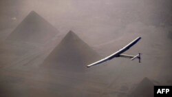 FILE - This handout photo released by Solar Impulse 2 shows the solar-powered plane, piloted by André Borschberg, during the flyover of the pyramids of Giza prior to landing in Cairo, July 13, 2016. 