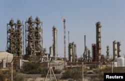 FILE — Pipelines are seen at the industrial zone at the oil port of Brega, Libya, Jan. 12, 2017.