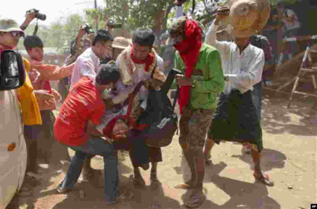 Demonstran mahasiswa menggotong temannya yang pingsan dalam demonstrasi di Letpadan, Myanmar (10/3). (AP/Gemunu Amarasinghe)