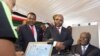 Kenyan President Mwai Kibaki (R) registers as a voter before launching the nationwide, one-month biometric voter registration (BVR) exercise in the capital Nairobi, November 19, 2012, targeting over 18 million voters ahead of the March 4 election.