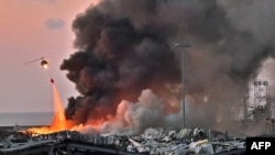 Un hélicoptère éteint un incendie sur les lieux d'une explosion dans le port de Beyrouth, la capitale du Liban, le 4 août 2020. (Photo AFP)