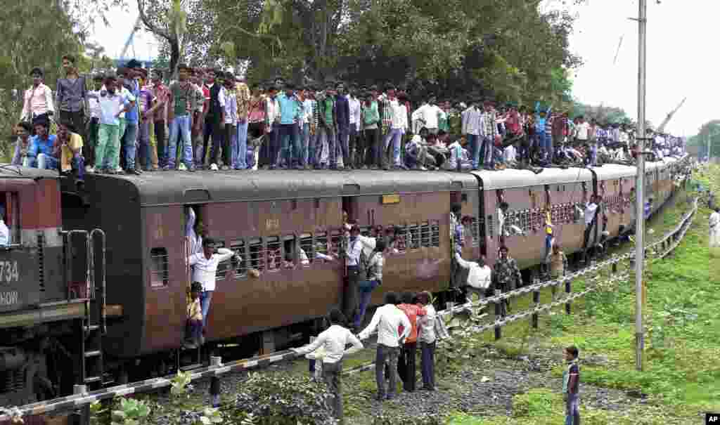 Warga Hindu-India bepergian di atas sebuah kereta yang penuh sesak untuk menghadiri festival keagamaan Guru Purnima di Khandwa, negara bagian Madhya Pradesh, India.