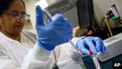 FILE - A lab technologist tests a patient's swab for a flu infection at Upson Regional Medical Center in Thomaston, Ga., Feb. 9, 2018.