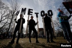 FILE - Demonstrators spell out "#MeToo" during the local second annual Women's March in Cambridge, Mass., Jan. 20, 2018.