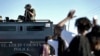 A member of the St. Louis County Police Department points his weapon in the direction of a group of protesters in Ferguson, Missouri, Aug. 13, 2014. 