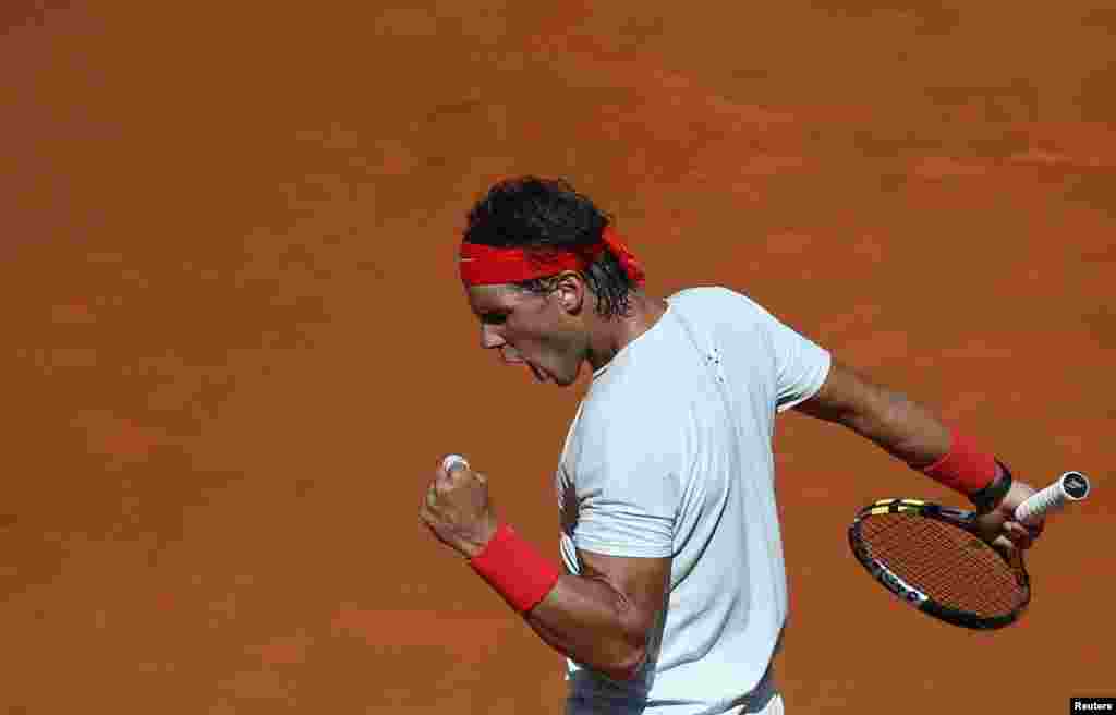 Petenis Spanyol, Rafael Nadal merayakan poin dalam pertandingan melawan petenis Rusia, Mikhail Youzhny dalam turnamen Madrid Open di Madrid, Spanyol. Unggulan ke-5 Rafael Nadal menang mudah 6-2, 6-3. 