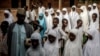 Un groupe d'étudiants peuls fait la queue sur les terrains de l'école avant le début des cours de la journée à l'école nomade Wuro Fulbe de la réserve de Kacha Grazing pour peuple Peul, État de Kaduna, au Nigeria, le 19 avril 2019.