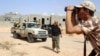 A fighter from forces aligned with Libya's new unity government monitors Islamic State locations at Algharbiyat area in Sirte, June 21, 2016.