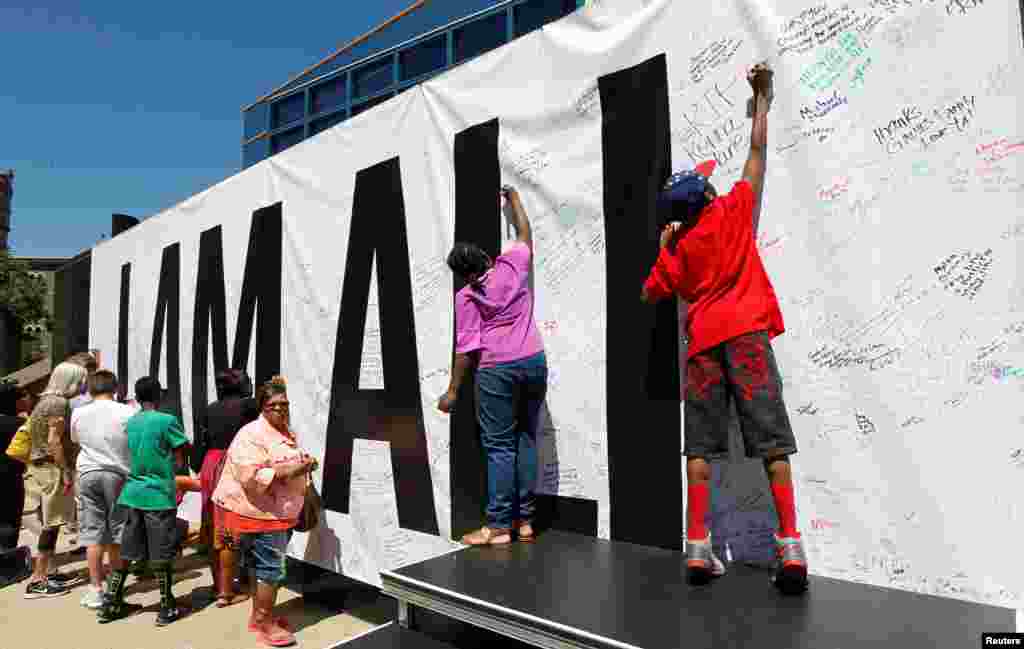 Fans of the late Muhammad Ali sign a large banner at the I AM ALI event to celebrate his life at the Kentucky Center of the Performing Arts in Louisville, Ky., June 8, 2016. 