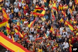 People wave Spanish national flags as thousands packed the central Cibeles square to in Madrid, Spain, Saturday, Sept. 30, 2017.