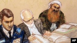 A sketch by a courtroom artist shows self-proclaimed terrorist mastermind Khalid Sheikh Mohammed, right, as he reviews court documents with his lawyers during the pre-trial hearing at the Guantanamo Bay U.S. Naval Base in Cuba, Feb. 12, 2013.
