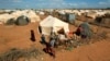 FILE - Refugees stand outside their tent at the Ifo Extension refugee camp in Dadaab, near the Kenya-Somalia border, Oct. 19, 2011. Ahmed Warsame, the new UNHCR director for global emergencies has led UNHCR operations in Dadaab.