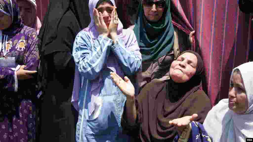 Seorang perempuan berduka cita di luar perkemahan pendukung Morsi di Kairo (27/7). (VOA/Elizabeth Arrott). 
