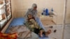 FILE - A Somali refugee holds a toddler at a hospital in the Dadaab refugee camp, Kenya, Dec. 19, 2017.