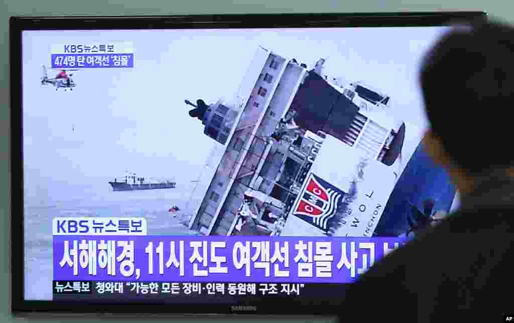 Seorang pria menonton siaran berita televisi yang menunjukkan tenggelamnya kapal penumpang, di stasiun kereta api di Seoul, Korea Selatan (16/4).&nbsp;(AP/Ahn Young-joon)