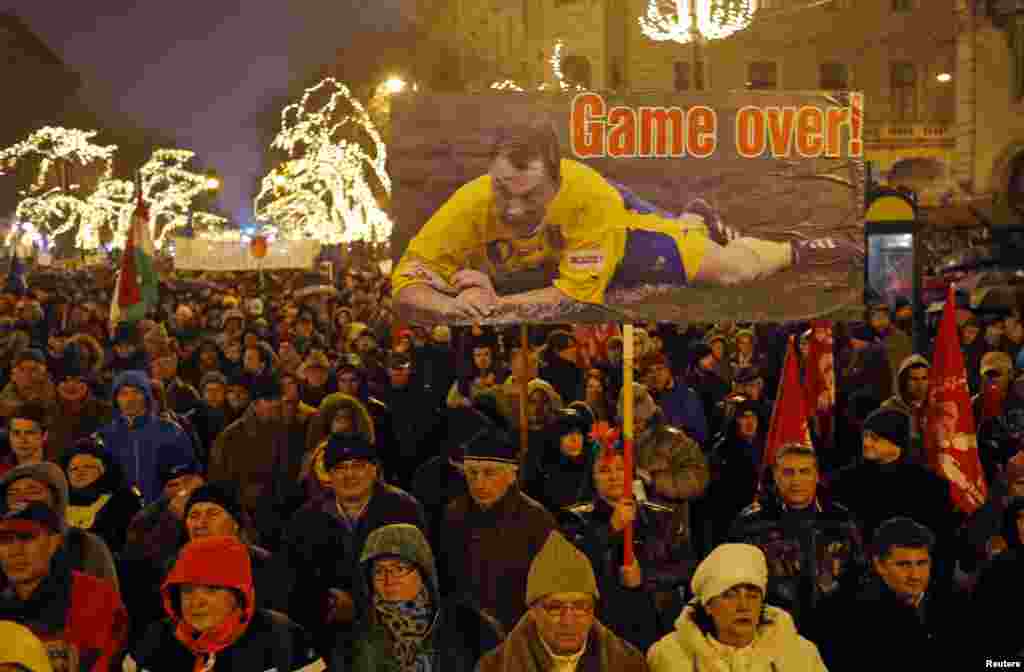 A woman holds a placard showing Hungarian Prime Minister Viktor Orban as a soccer player during an anti-government protest called by civil groups in Budapest. The protest follows a number of other rallies against Orban's government, which has seen a plunge in popularity over the past months.