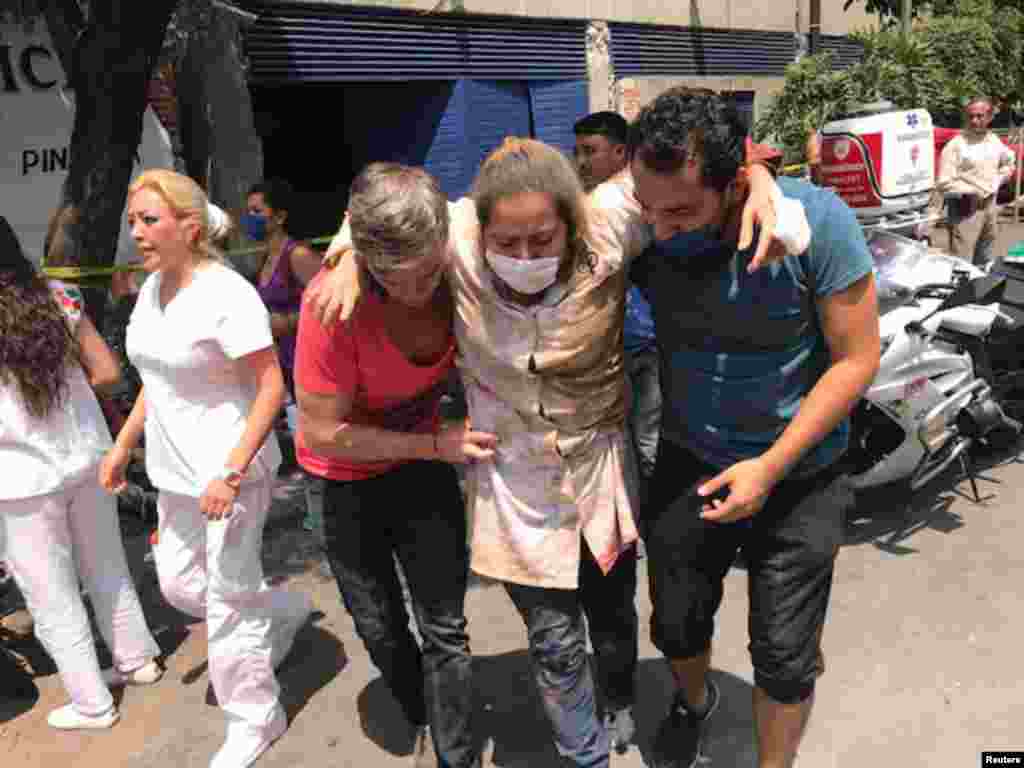 People help an injured person after an earthquake hit in Mexico City, Sept. 19, 2017.