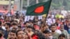 A student carrying the Bangladeshi flag takes part in a march as demonstrators demand justice for victims arrested and killed in the recent nationwide protests against job quotas, in Dhaka on Aug. 3, 2024.