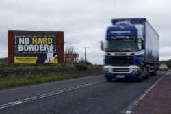A truck races past a sign against the reestablishment of a hard border between Northern Ireland and the Republic of Ireland, Oct. 1, 2019.