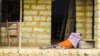 In this Tuesday, Oct. 21, 2014 file photo, a man suffering from the Ebola virus lies on the floor outside a house in Port Loko Community, situated on the outskirts of Freetown, in Sierra Leone. (AP Photo/Michael Duff, File)
