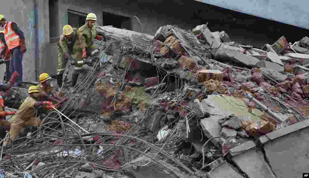 Indian rescue workers search for survivors in the rubble of a collapsed building in Canacona, India, Jan. 5, 2014. 