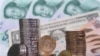 FILE - Coins, banknotes of Chinese yuan paired with a U.S. dollar during photo illustration, Fuyang, Anhui province, November 2006.