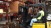 Ex-offender Wade Tate drives a forklift for DSI Warehouse in greater Memphis, Tenn. His boss says customers ask to meet Tate in person to offer thanks for his computer assistance with their orders. (C. Presutti / VOA)