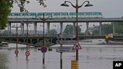Road signs emerge on the banks of the Seine river next to the Bir Hakeim bridge during floods in Paris, France, June 4, 2016.