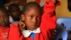 A student raises her hand to ask a question during class at the Kibera School for Girls in Nairobi, Kenya, March 19, 2013.(J. Craig/VOA)