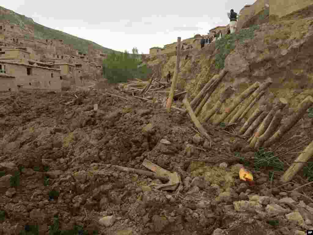 Warga mencari penyintas menyusul tanah longsor masif yang menimbun satu desa di provinsi Badakhshan, timur laut Afghanistan (2/5). (AP/Ahmad Zubair)