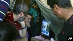 Families of missing soldiers, who were kidnapped by militants from the Islamic State group and al-Qaida's affiliate in Syria, the Nusra Front, watch news on a television about a possible prisoners exchange between Lebanon and the Nusra Front, in tents set for their protest in downtown Beirut, Lebanon, Nov. 29, 2015. 