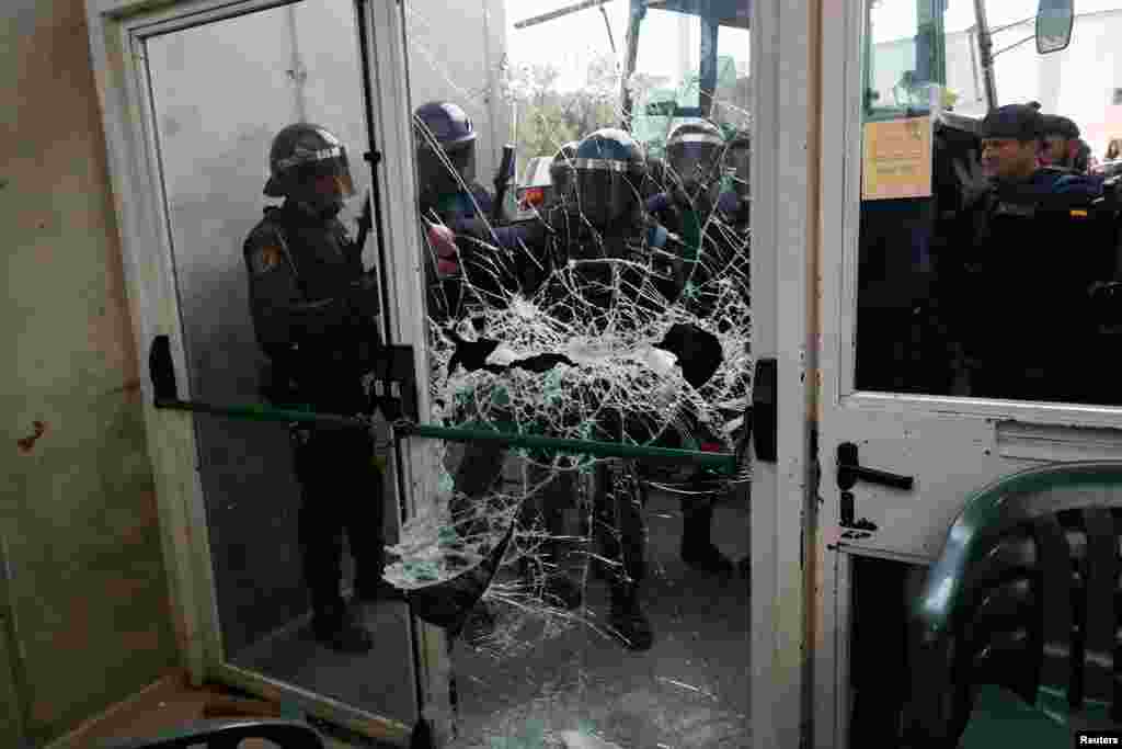 Spanish Civil Guard officers break through a polling station for the banned independence referendum where Catalan President Carles Puigdemont was supposed to vote in Sant Julia de Ramis, Oct. 1, 2017.